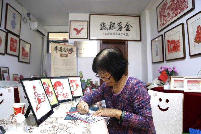 Paper-cut artist, 76, blends AI to cheer on Pingtan's football team